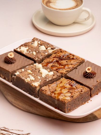 A platter showcasing my assortment of brownies. It includes the Dulce De Leche, Cookie Dough, and Chocolate Hazelnut varieties, offering something for every chocolate lover.