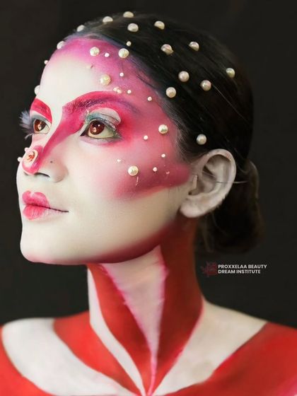 A close-up on the face, showing the intricate pearl placement and the striking red graphic details around the eyes.