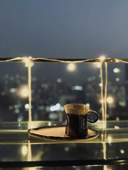 The metallic bronze mug with its matching organically shaped plate. This set embodies our design philosophy of intentional imperfection.