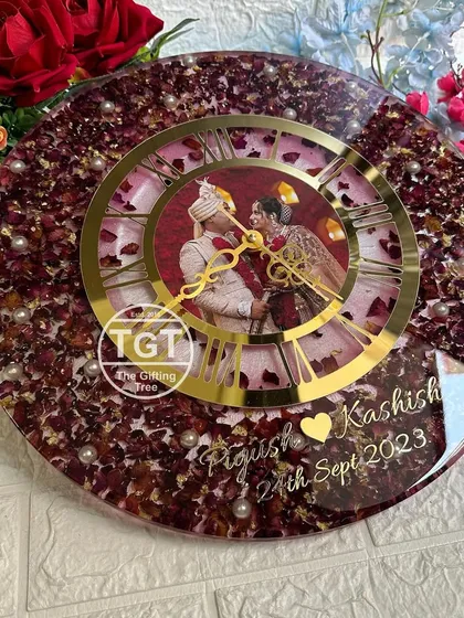 A full-frontal view of the clock, showcasing the beautiful arrangement of petals and the central placement of the couple's photo.