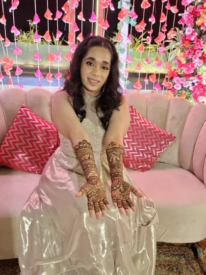A full view of the bride and her mehndi. The intricate patterns stand out beautifully against her elegant outfit, making her shine even brighter.