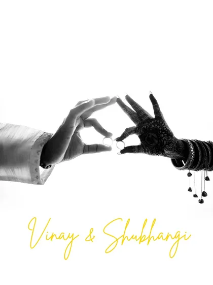 A creative and symbolic black and white shot of the couple's hands forming a heart shape with their engagement rings. This minimalist image is a powerful representation of their union.