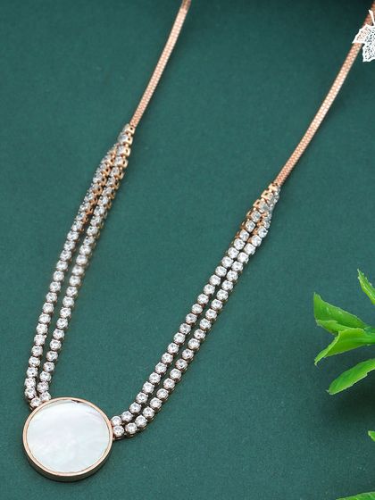 The Moonlight Shell necklace, featuring a double strand of diamonds leading to the central mother of pearl disc.