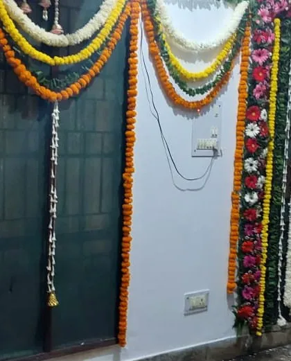 This image shows how we decorate interior doors and walls with hanging flower garlands. We use different combinations of white, yellow, and orange flowers to match the event's theme.