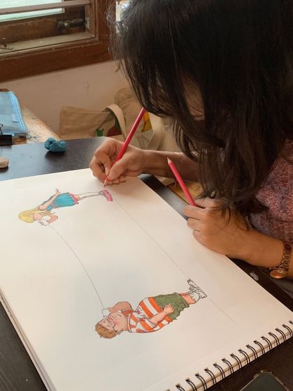 A student brings a cartoon drawing to life with colored pencils, showing the fun and playful side of art.