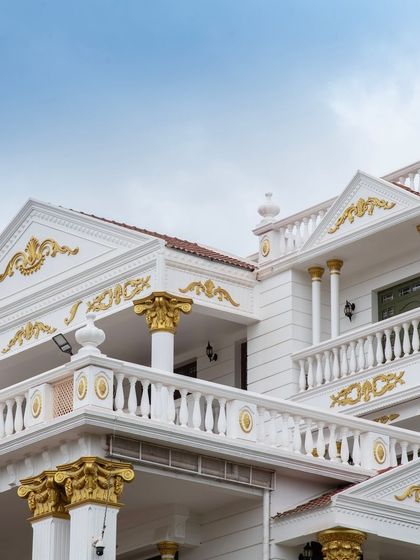 A close-up of the palace's facade, detailing the intricate gold-leaf work on the cornices and column capitals, a hallmark of its royal aesthetic.