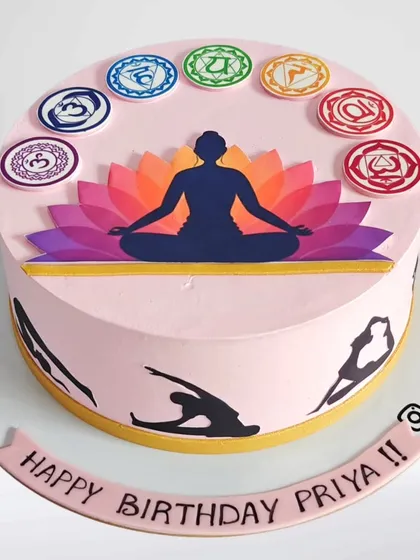A serene yoga-themed cake for a yoga lover's birthday. The design features the seven chakras and silhouettes of various yoga poses around the side.
