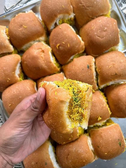 A close-up of my Jain Vada Pav, stuffed with a delicious potato filling and sprinkled with sev. It's a classic street food snack made pure Jain.