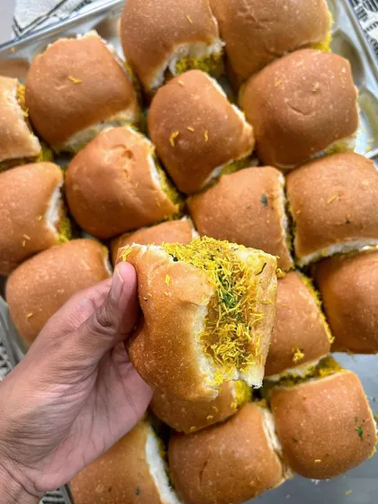 A close-up of my homemade Kutchi Dabeli, a sweet and spicy potato filling stuffed in a soft pav, garnished with sev.