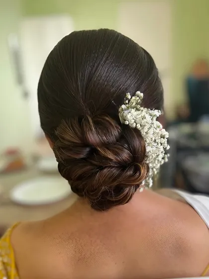 A beautiful braided bun with a touch of baby's breath. This is a soft and romantic look for any special occasion.