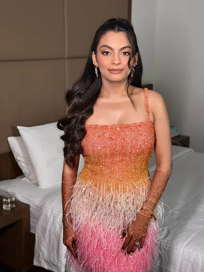 A full view of the snatched cocktail look. The ombre feather dress is a statement, and the makeup is bold and timeless to match.