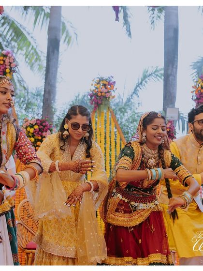 Embracing tradition with a twist. The bride and groom join in for a Ghoomar dance performance during their Rajasthani Mela-themed Haldi, creating a culturally rich and fun experience for everyone.