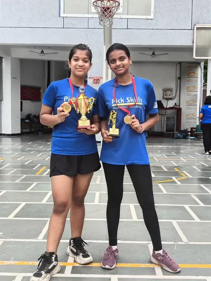 Two of our standout players from the junior girls' team proudly displaying their winner's trophy and MVP award. Their performance is a direct result of the discipline and advanced skills we cultivate at the academy.