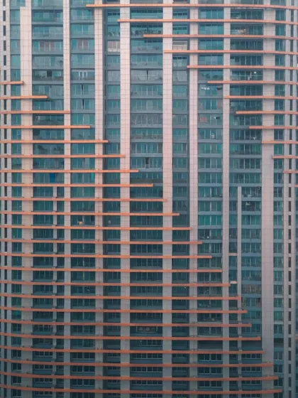A close-up of a modern building's facade, focusing on the grid-like pattern of windows and panels. This abstract architectural shot finds beauty in the repetition and texture of the urban environment.