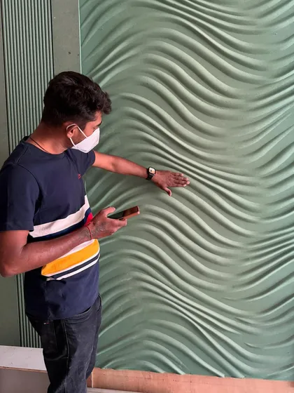 Inspecting the texture and finish of the 3D wall panel up close. Quality control is a continuous process.