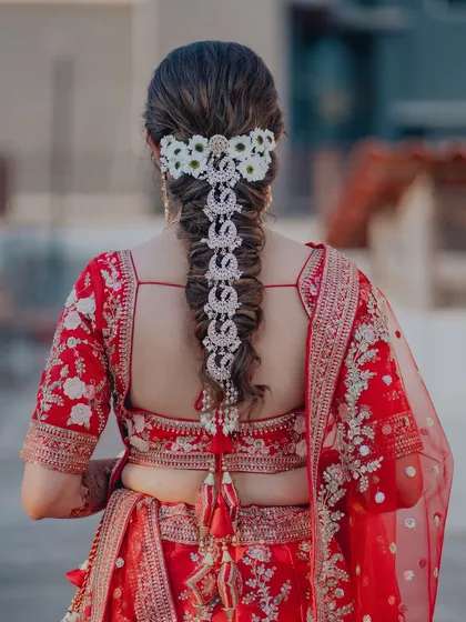 A bridal hairstyle should be a work of art. This dreamy braid, intricately woven with fresh flowers and delicate jewels, was the perfect finishing touch for this bride's fairytale wedding look. It’s all about creating magic in the details.