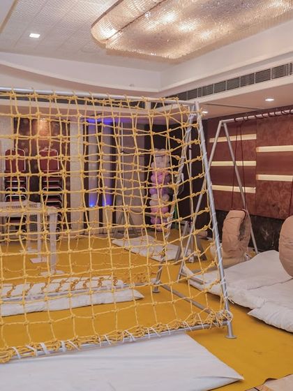 An indoor adventure zone featuring a rope climbing net and tire swings. I can transform an indoor space into a challenging and fun obstacle course.