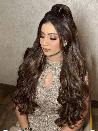 Princess vibes only. This half-up style with voluminous curls is perfect for a reception or engagement, creating a truly royal look.