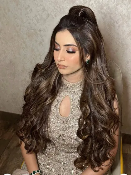 Princess vibes only. This half-up style with voluminous curls is perfect for a reception or engagement, creating a truly royal look.