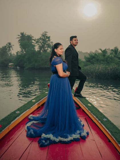A cinematic shot against the setting sun. The blue ruffled gown and the beautiful backlighting create a dreamy and romantic pre-wedding photo.