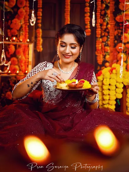 A perfect look for a Diwali night celebration. This image from a festive photoshoot captures a warm, glamorous makeup style with defined eyes and glowing skin, set against a beautiful backdrop of diyas and marigolds.