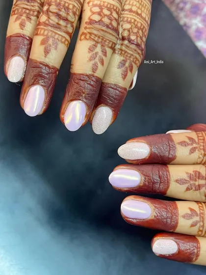 A beautiful pearl chrome and glitter nail set that perfectly complements this bride's intricate henna design.