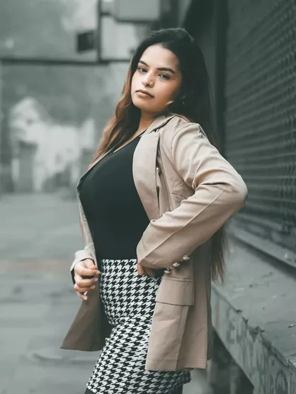 A three-quarter portrait with a strong pose. The composition is clean and effective, highlighting the model's confidence and the sharp lines of the outfit.