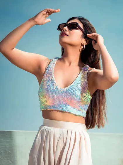 A sunny, outdoor shot perfect for a summer collection lookbook. The sequined top catches the light beautifully, and the pose feels natural and aspirational.