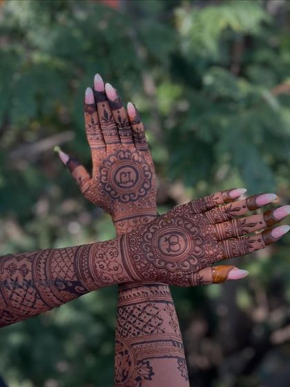 A creative pose showing the crossed arms, which brings the two central mandala designs with the initials together.