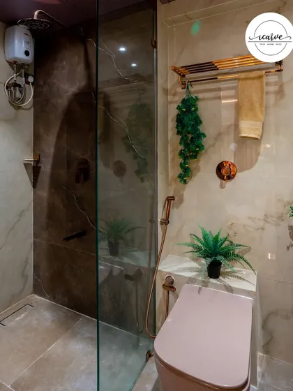 A view of the shower area, separated by a glass partition. The dark accent tile in the shower adds depth and contrast to the space.