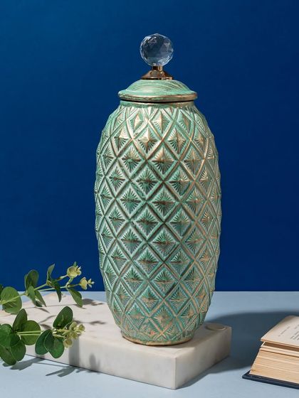 This decorative jar in a lovely seafoam green features a textured diamond pattern and a crystal knob. It's a beautiful piece for adding a subtle pop of color to a shelf or vanity.