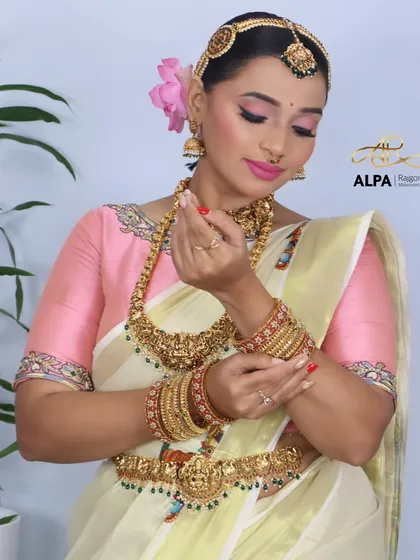 The bride showcasing her waist belt (vaddanam) and the complete set of temple jewelry.