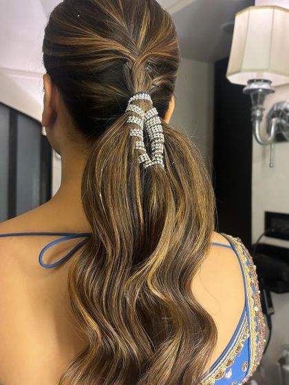 A close-up of the wavy ponytail with a stunning wrap-around crystal accessory. I teach how to create these soft waves and securely attach accessories for a polished look.
