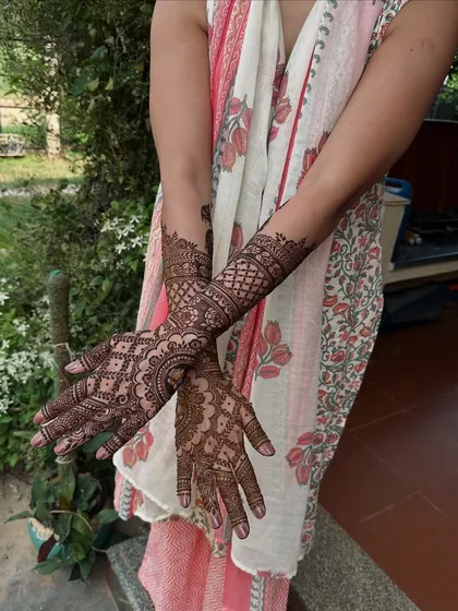 A classic design featuring a large central mandala on the back of the hand, with detailed jaali work extending up the arm for a complete festive look.