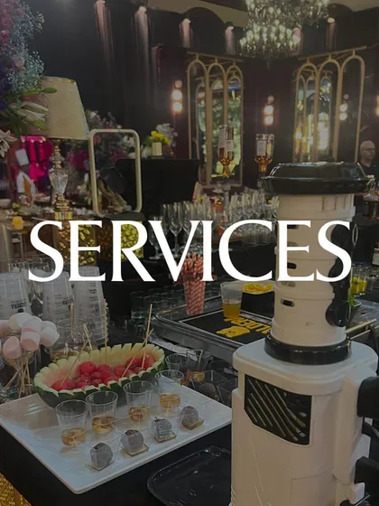 A wide shot of a fully serviced event bar, complete with a fruit display, marshmallows for garnishes, and our professional team ready to serve. We provide an end-to-end service.