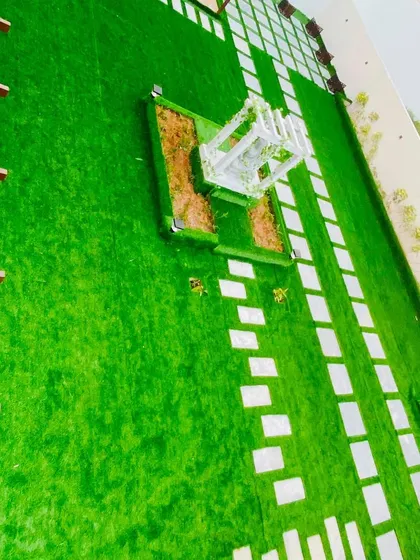 An aerial view of a large landscaped area, showing how our artificial turf and paver design creates a grand and organized layout for a property entrance or courtyard.