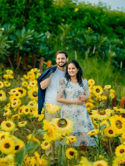 A vibrant and joyful pre-wedding shot of Sayali and Siddhesh in a field of sunflowers. This natural, colorful setting is perfect for fun and happy couple portraits.