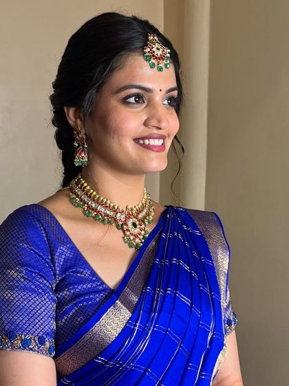 A portrait of the bride, the saree draped neatly to showcase her beautiful necklace and earrings.