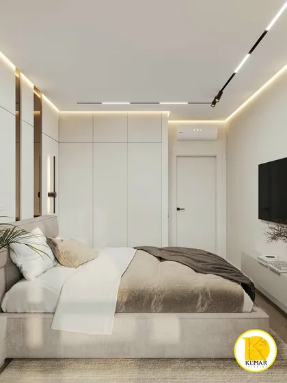 A contemporary bedroom with white wardrobes and track lighting on the ceiling. The design is clean, bright, and makes the most of the space.