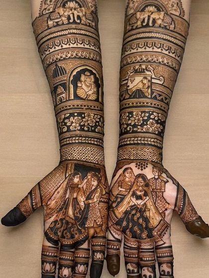 This full-coverage bridal design tells a story from fingers to elbows. It features multiple couple portraits, a Ganesha motif, and a doli scene, all woven together with intricate patterns.