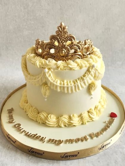 A small but regal cake with English buttercream piping and a beautiful gold sugar crown on top.