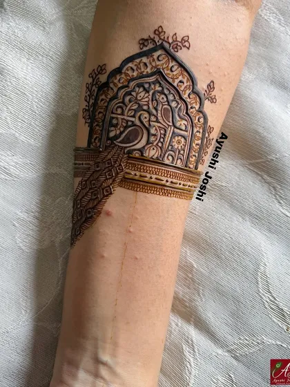 Another armband detail from the baby shower design, showing a peacock and parrot pair within a traditional 'jharokha' or window frame.