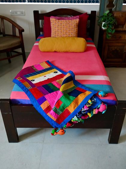 An improv quilt made entirely from scrap fabric and studio waste, seen here as a colorful bed runner. Creating a fully upcycled product like this brings me immense satisfaction.