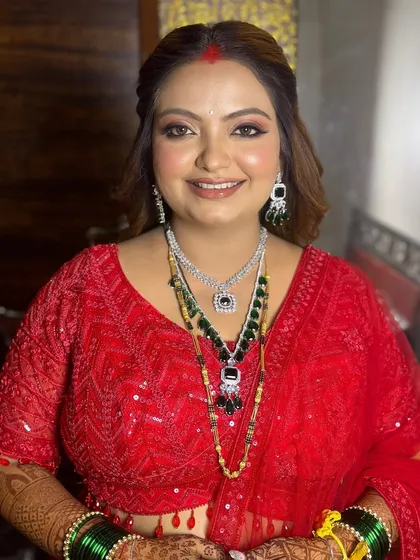 A bold and beautiful reception look in a stunning red outfit, with glamorous makeup to match.