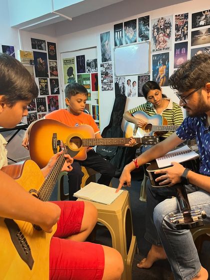 A bustling group guitar class. Learning in a group is a great way to stay motivated, make friends, and learn to play in time with others.