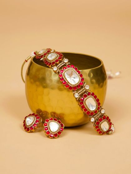 A beautiful flat-lay of our red and white Kundan choker set. This piece is perfect for adding a pop of color to any festive or wedding outfit.