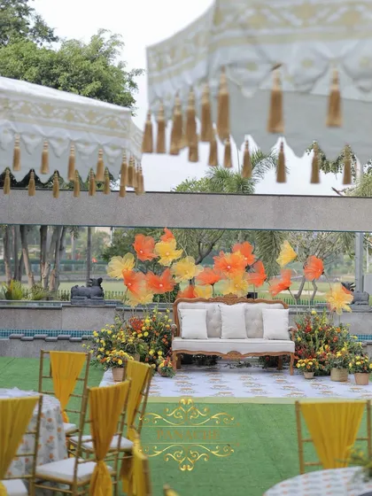 Another angle of the Haldi stage, framed by elegant white and gold tasseled umbrellas.