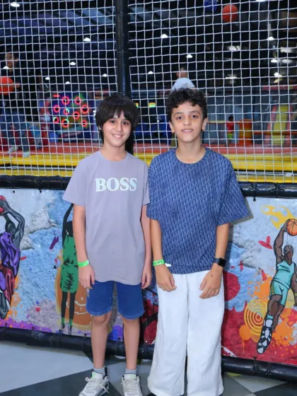 Two friends hanging out by the graffiti wall in our play zone. It's a cool spot for older kids to chill between activities.