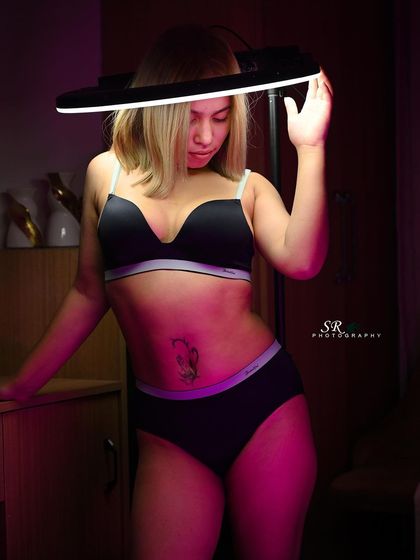 A creative portrait using a ring light as a prop, framing the model's face and creating a futuristic, edgy look.