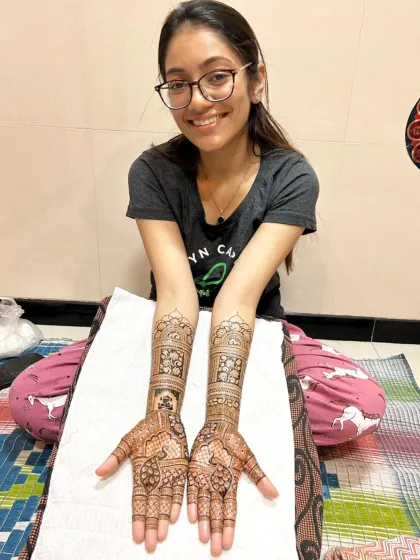 The happy client with her completed bridal mehndi, ready for her big day.